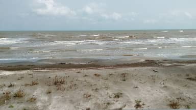 Песчаный берег Каспийского моря и набегающие волны в Астаре.