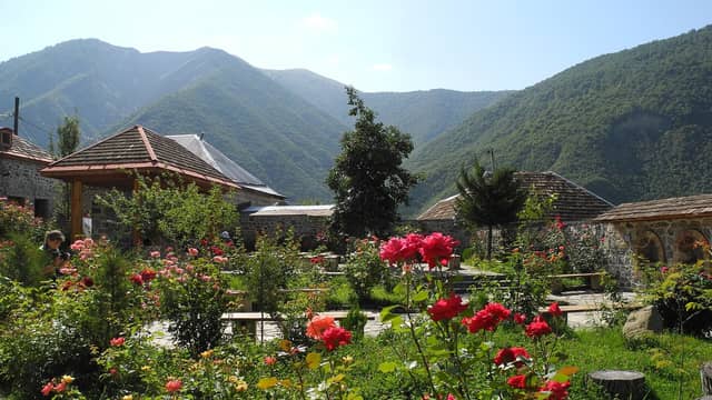 Meşəli dağların ətəyində Kiş kəndindən güllü həyət və evlər.