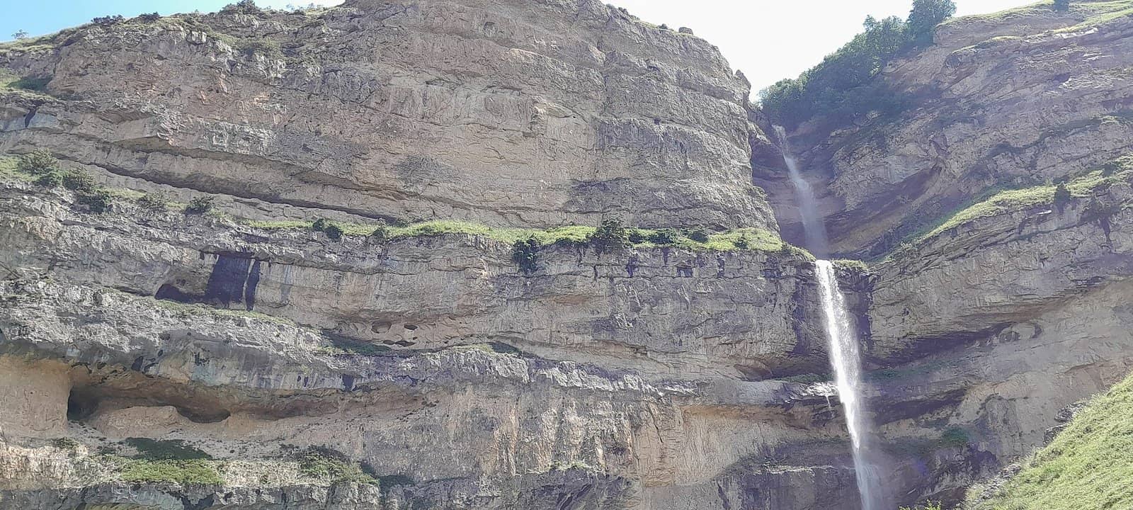 Laza kəndi ətrafında hündür laylı qaya divarından tökülən ensiz şəlalə.