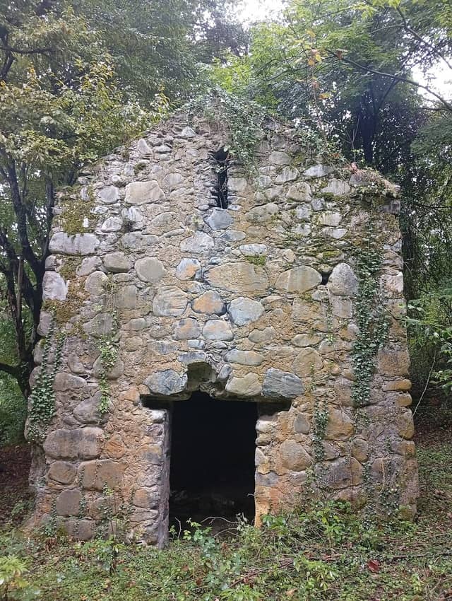 Ağaclar arasında tağlı qapısı olan kiçik daş Mazımçay kilsəsi.