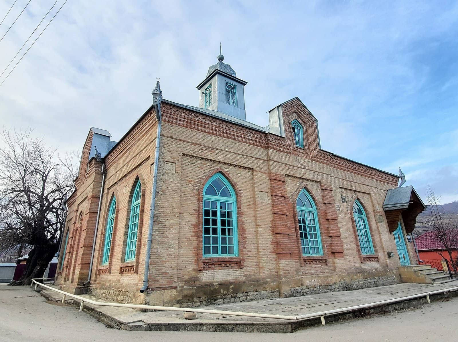 Rustov kəndində kərpicdən tikilmiş məscid, firuzəyi rəngli tağlı pəncərələri ilə.