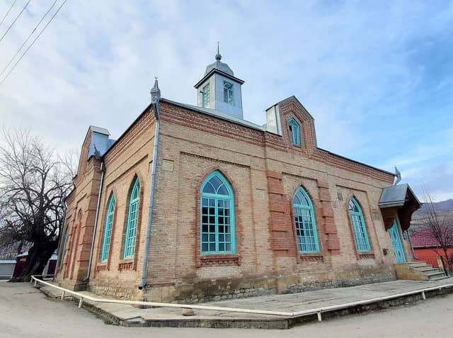 Rustov kəndində kərpicdən tikilmiş məscid, firuzəyi rəngli tağlı pəncərələri ilə.