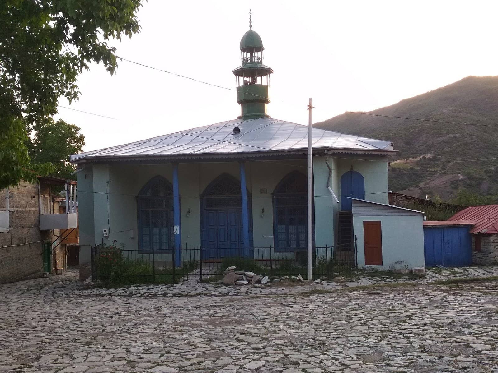 Lahıcda yaşıl minarəli Aşağı Aragit məscidi və daş döşənmiş meydan.