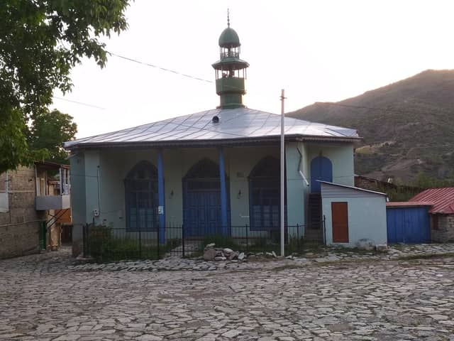 Lahıcda yaşıl minarəli Aşağı Aragit məscidi və daş döşənmiş meydan.