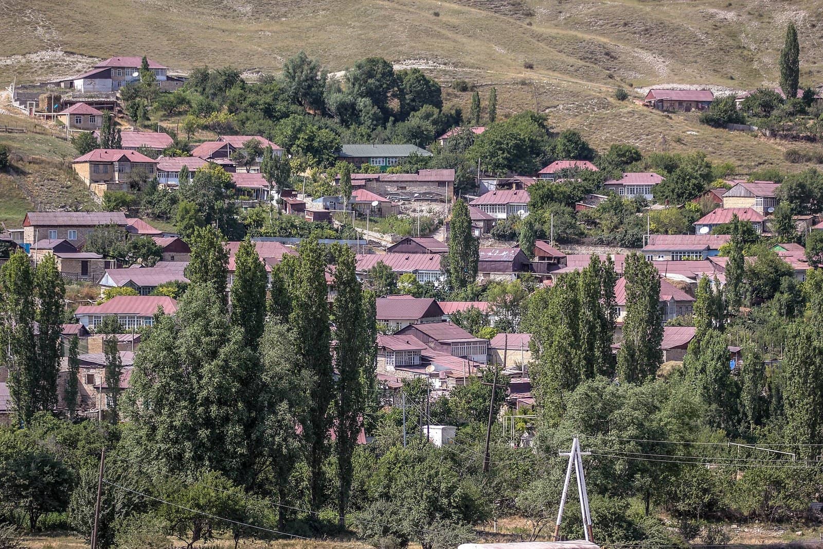 Dəmirçi kəndinin yamacboyu düzülmüş qırmızı damlı evləri və qovaq ağacları, Şamaxı rayonu