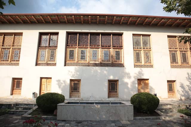 Ağ fasadlı, ikinci mərtəbəsində şəbəkə pəncərələri olan Şəkixanovların evi.