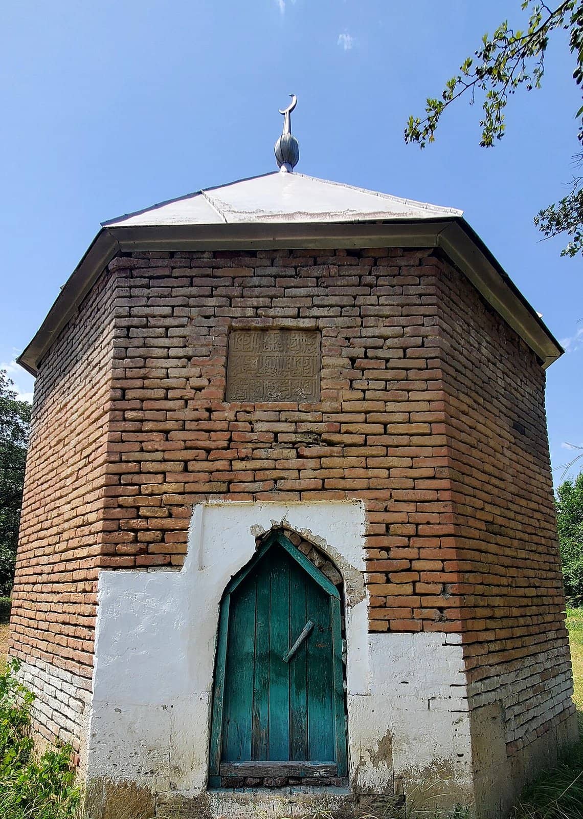 Ağbil kəndində səkkizguşəli kərpic türbə, girişin üstündə ərəb yazılı daş kitabə.